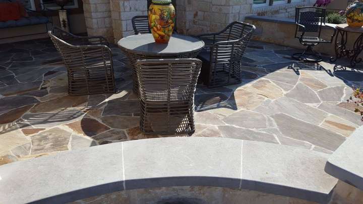 Flagstone patio with a dining table and a limestone seat wall