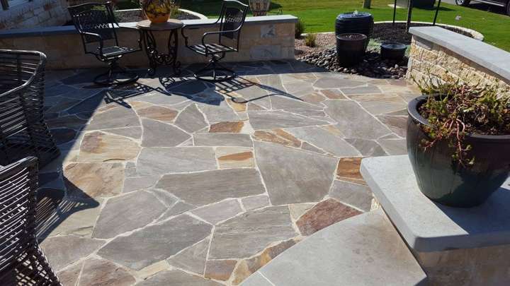 Irregular flagstone patio with iron chairs and a large planter