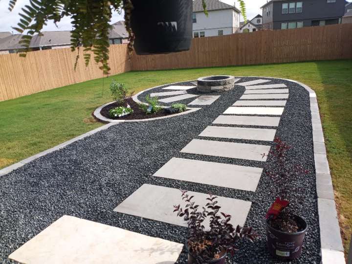 Gray Lueders stepping-stone path set in black gravel through a lawn