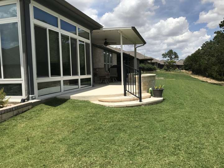 Solid patio cover over a concrete patio beside a lawn