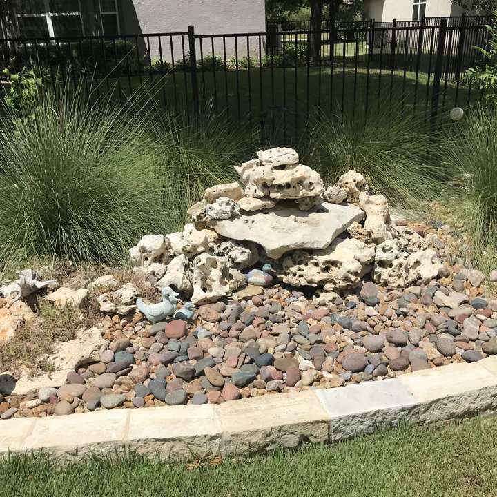 Stacked-stone bubbling fountain in a river-rock bed
