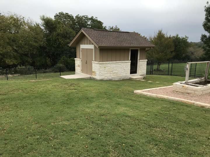 Small shed with a limestone skirt at the edge of a lawn
