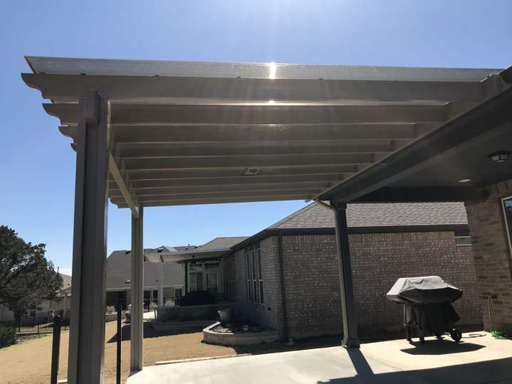 Slatted pergola over a concrete patio with a grill