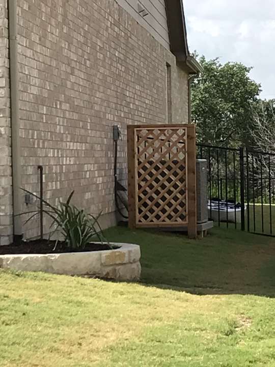 Cedar lattice privacy screen beside a house