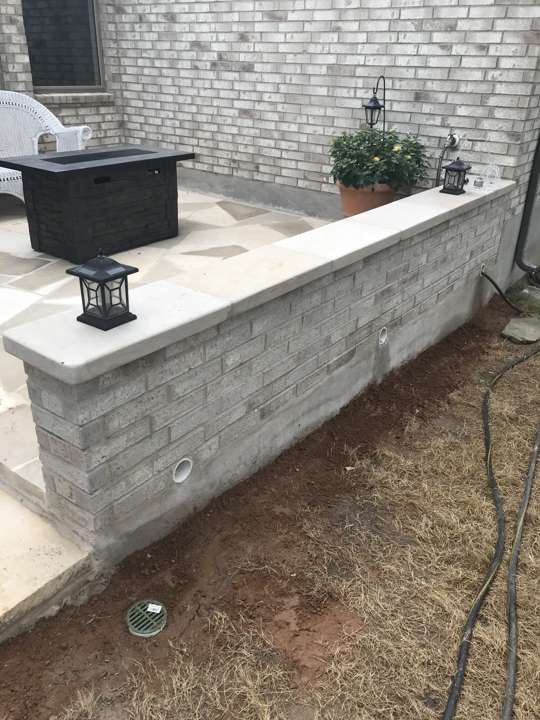 Limestone seat wall with a lamp post on a patio