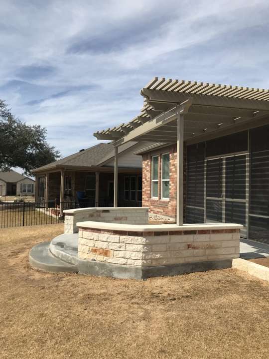 Pergola frame over a limestone seat wall