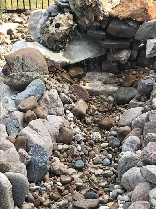 Dry-stack boulder water feature over river rock