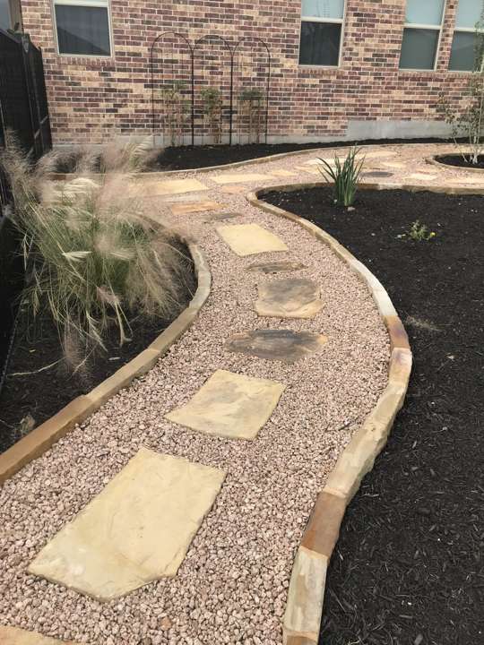 Decomposed granite path with flagstone steppers and limestone edging along a house