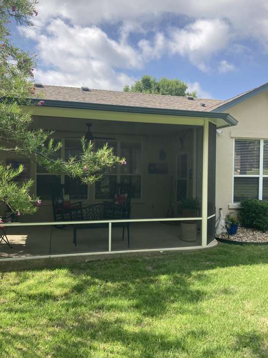 Screened patio enclosure at the back of a house