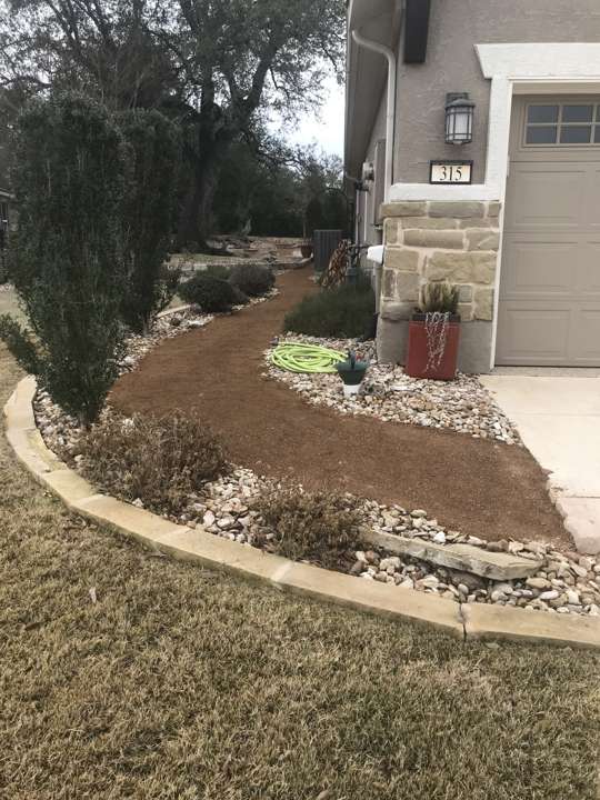 Decomposed granite path with limestone edging through a native bed to a front door