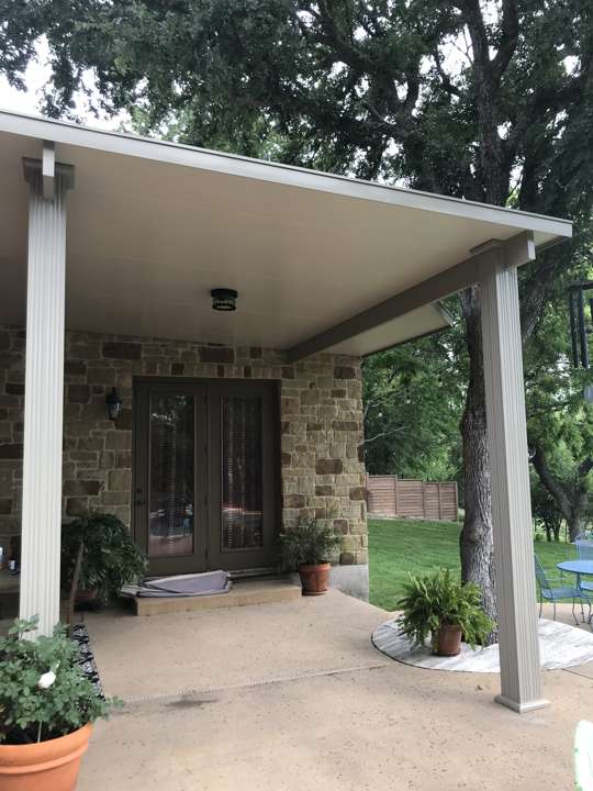 Solid-roof patio cover on a stone house