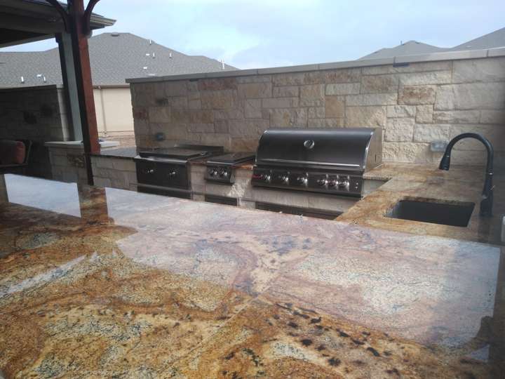 Granite-topped outdoor kitchen with grill and gooseneck faucet