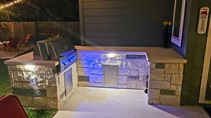 Outdoor kitchen with under-counter lighting at dusk