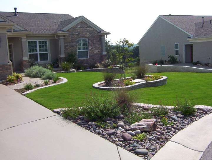 Front yard with a river-rock island bed and limestone edging