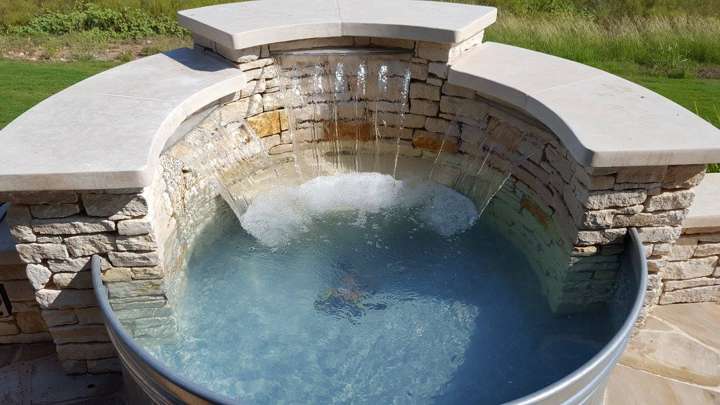 Stone spa spillway wall with a sheer-descent waterfall