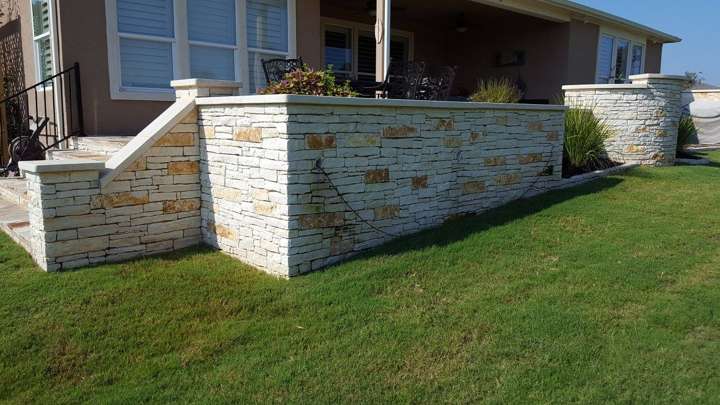 Chopped limestone seat wall framing a back patio