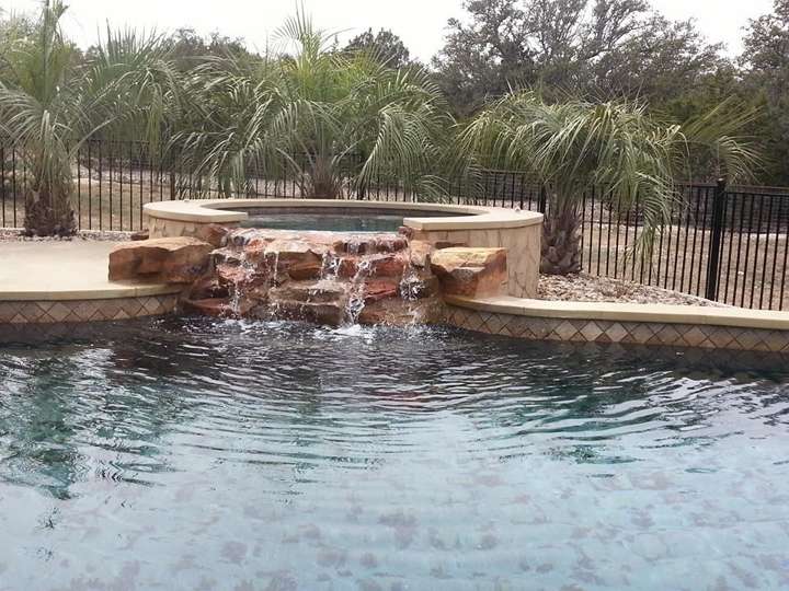 Stacked-stone waterfall into a pool with palms