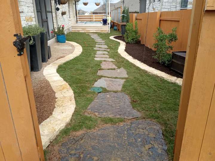 Flagstone stepping path through mulch beds along a narrow side yard