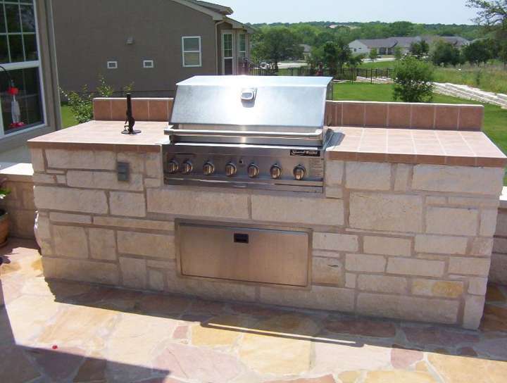 Straight limestone grill island with a travertine counter