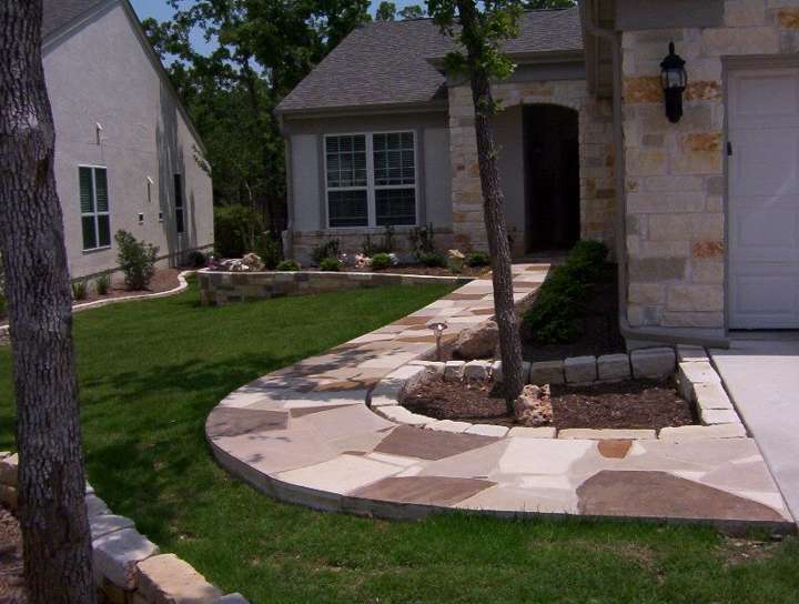Curved flagstone walkway to a front door under mature trees