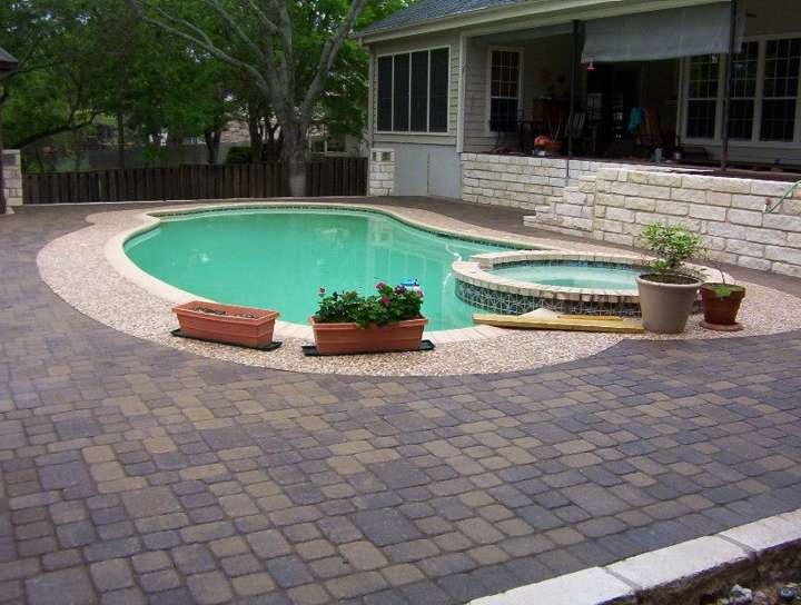 Paver pool deck with limestone coping and a raised spa