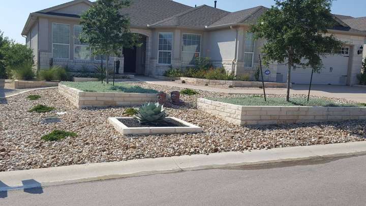 Low-maintenance front yard with decomposed granite, a raised limestone planter and native plants