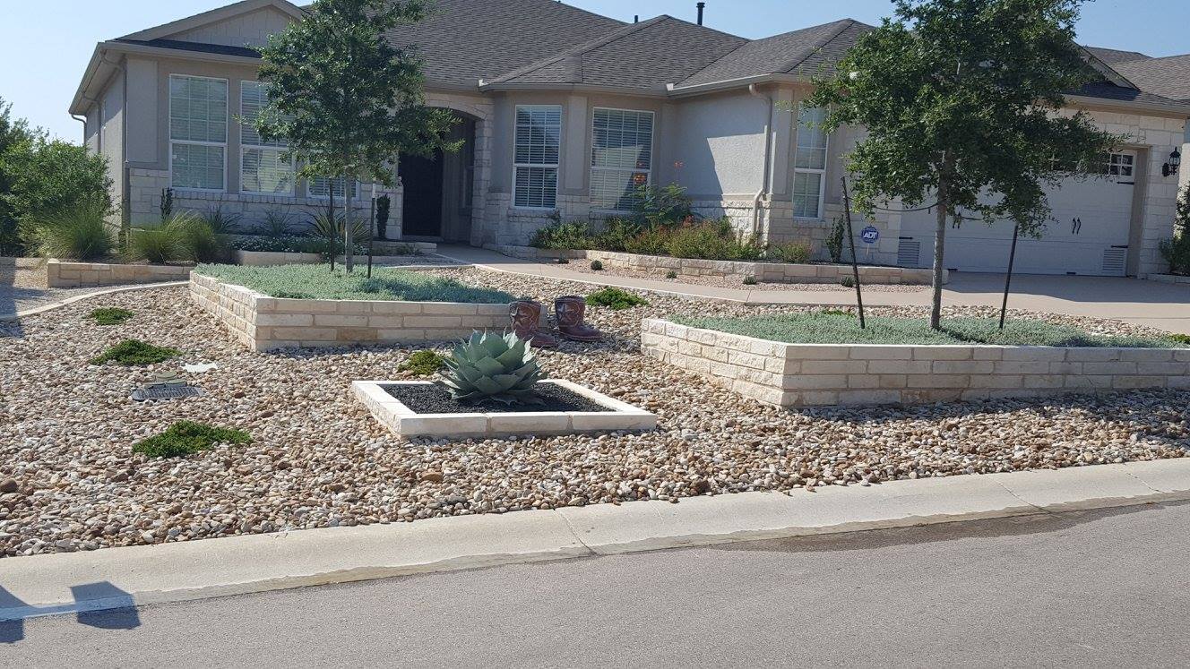 Low-maintenance front yard with decomposed granite, a raised limestone planter and native plants, a B&B project in Georgetown, Texas